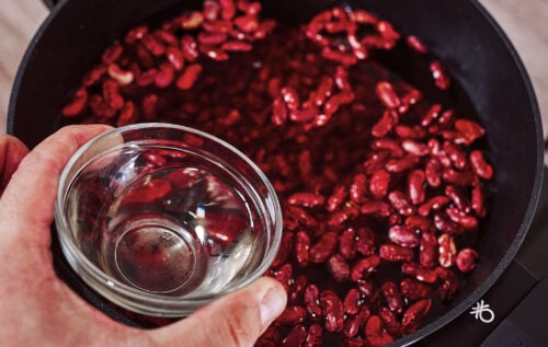 Step-by-step process of cooking red kidney beans in a pot – rinsed beans, covered with water, add the oil