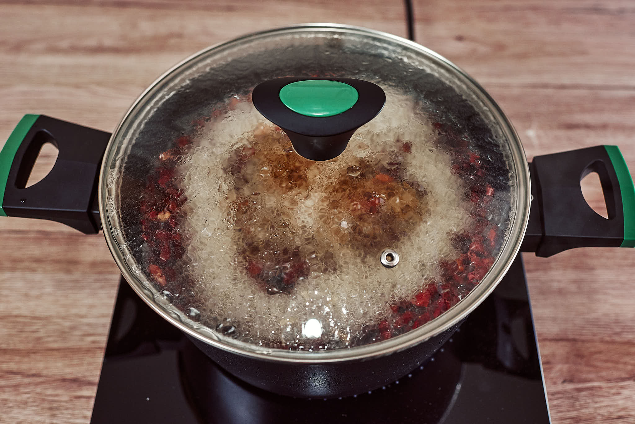 Red kidney beans in a pot being covered with water, salted, and simmered with the lid on.