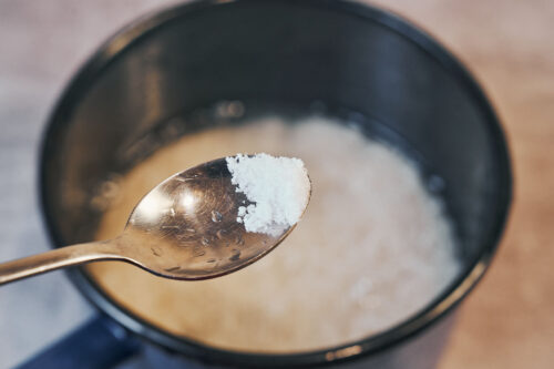 Adding salt to rice in a saucepan