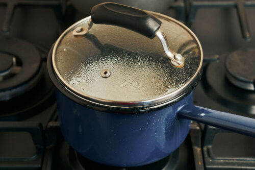 Rice cooking covered in a saucepan on the stove
