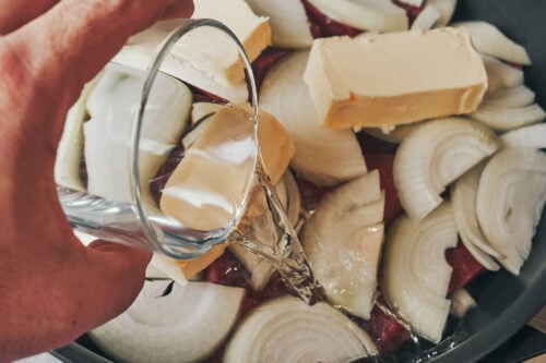 Water poured into skillet to create steam for slow cooked beef