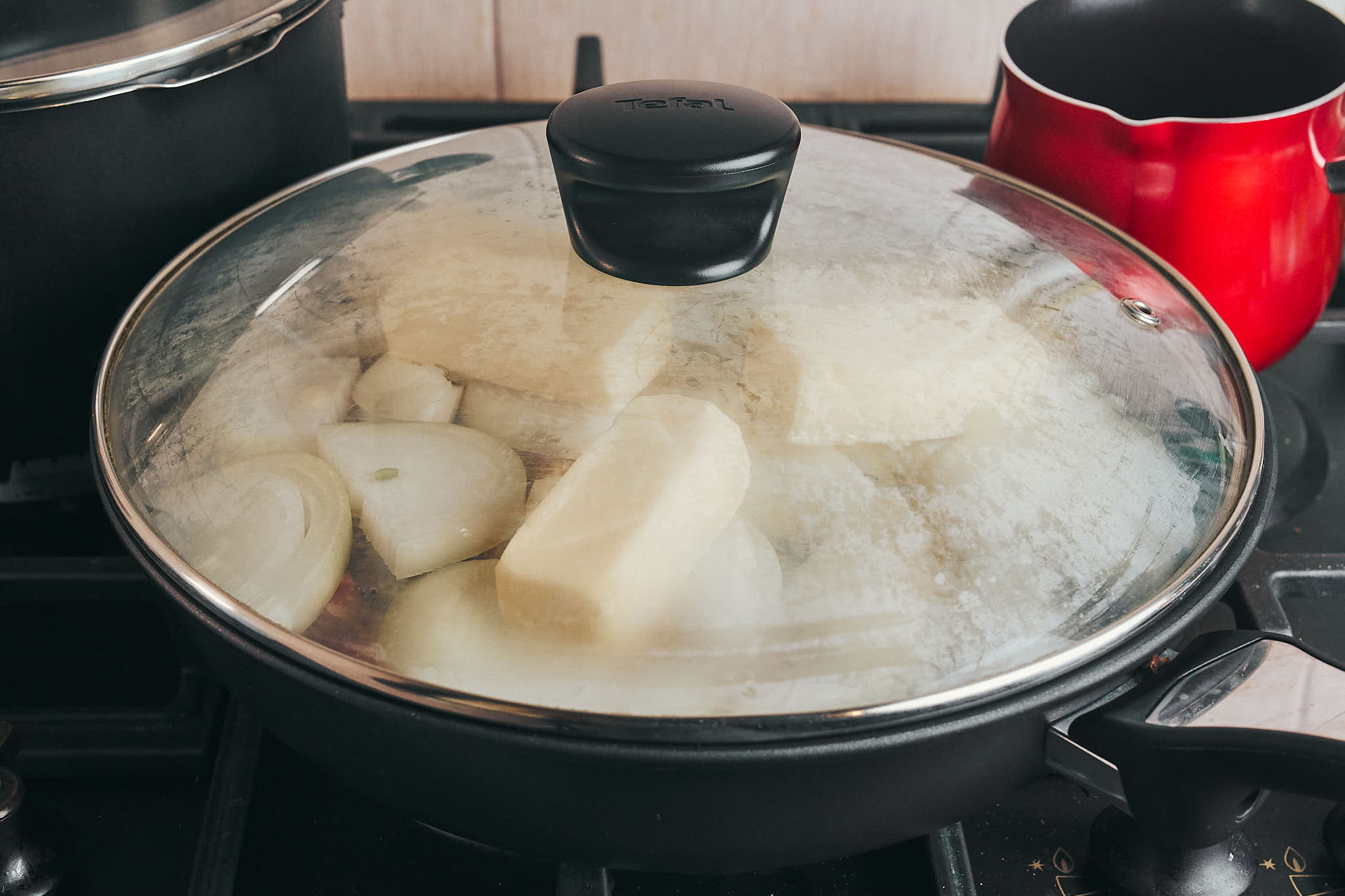 Skillet covered with lid while beef and onions slowly simmer