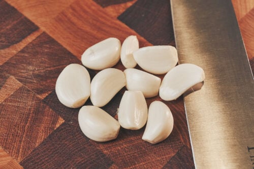 Peeled garlic cloves on a cutting board