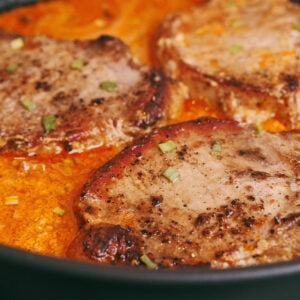 Creamy pork chops in sour cream sauce garnished with green onion