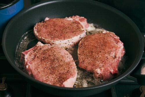 Seasoned pork chops added to a skillet