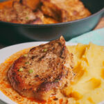 Creamy pork chops in sour cream sauce garnished with green onion