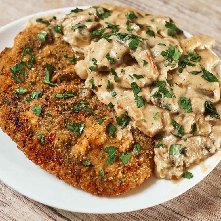 Crispy golden pork schnitzel topped with creamy mushroom sauce
