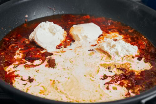 Cream cheese melting into the sauce in the skillet