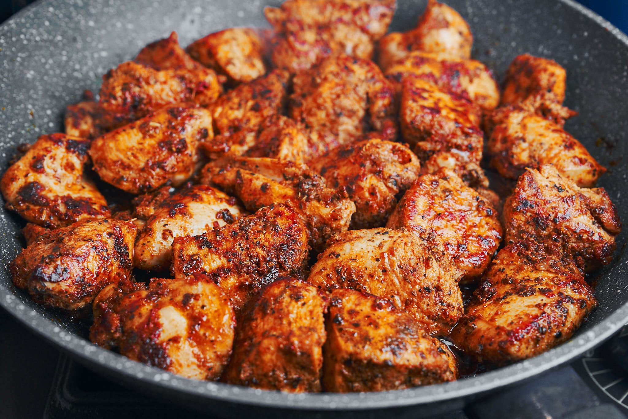 Golden seared chicken pieces in a skillet