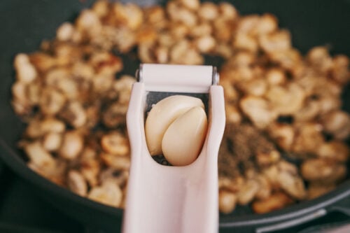 garlic added to sautéed mushrooms in the skillet