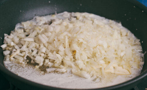 Chopped onion cooking in butter for creamy ground beef pasta