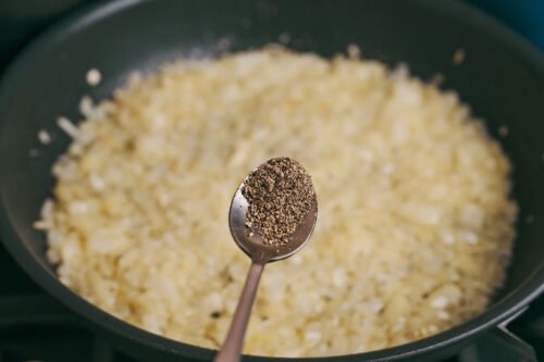 Adding black pepper to seasoned onion