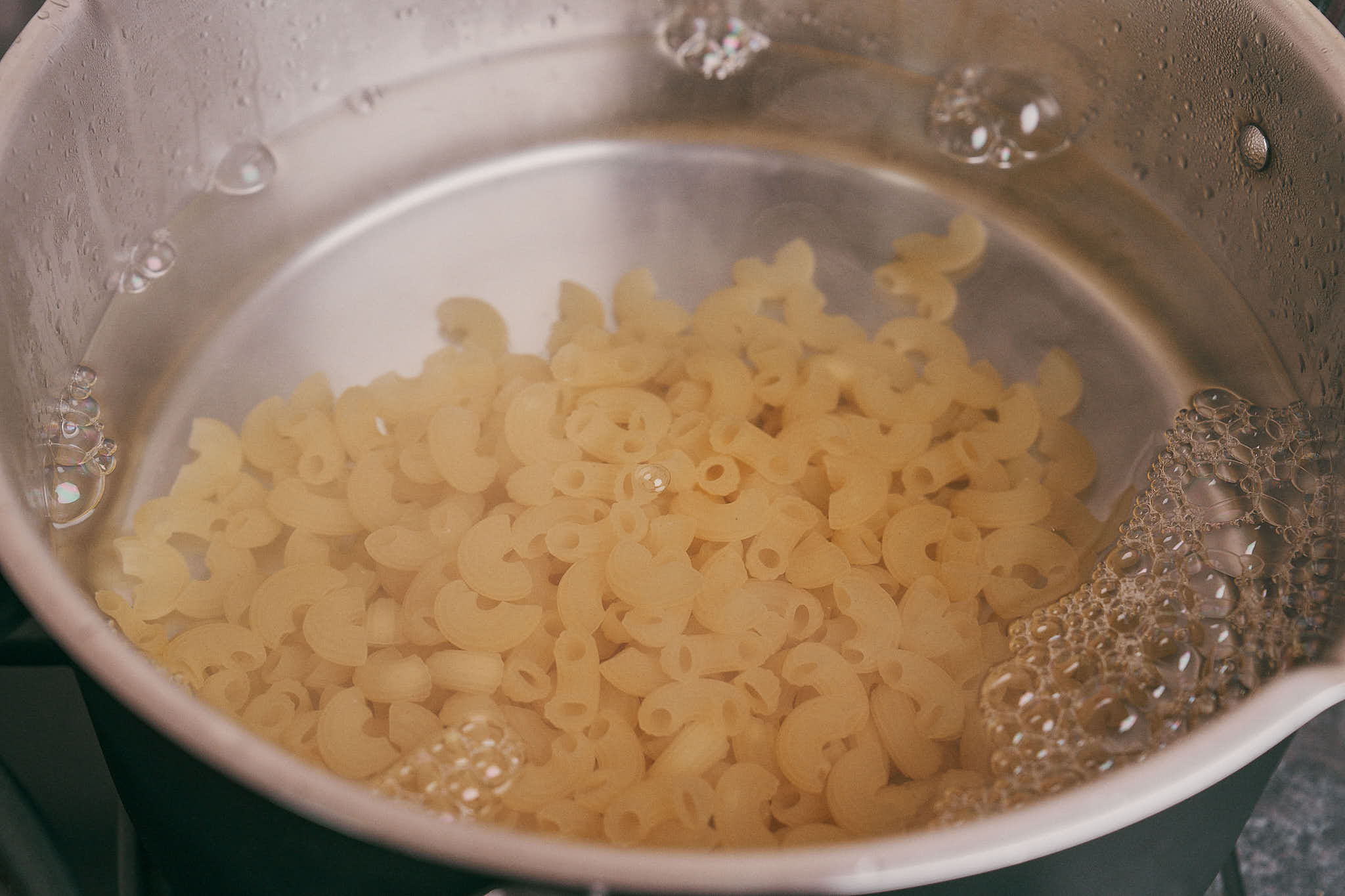 Elbow pasta cooking in salted boiling water