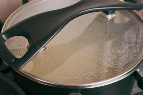 Pasta cooking in a covered pot of boiling water
