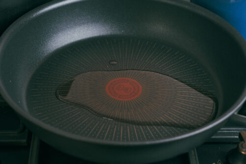 Olive oil heating in a skillet before adding ground beef