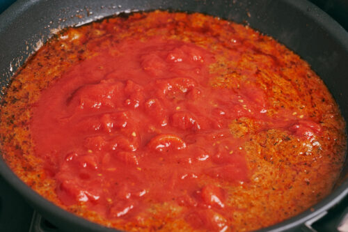 Adding tomato sauce to the skillet