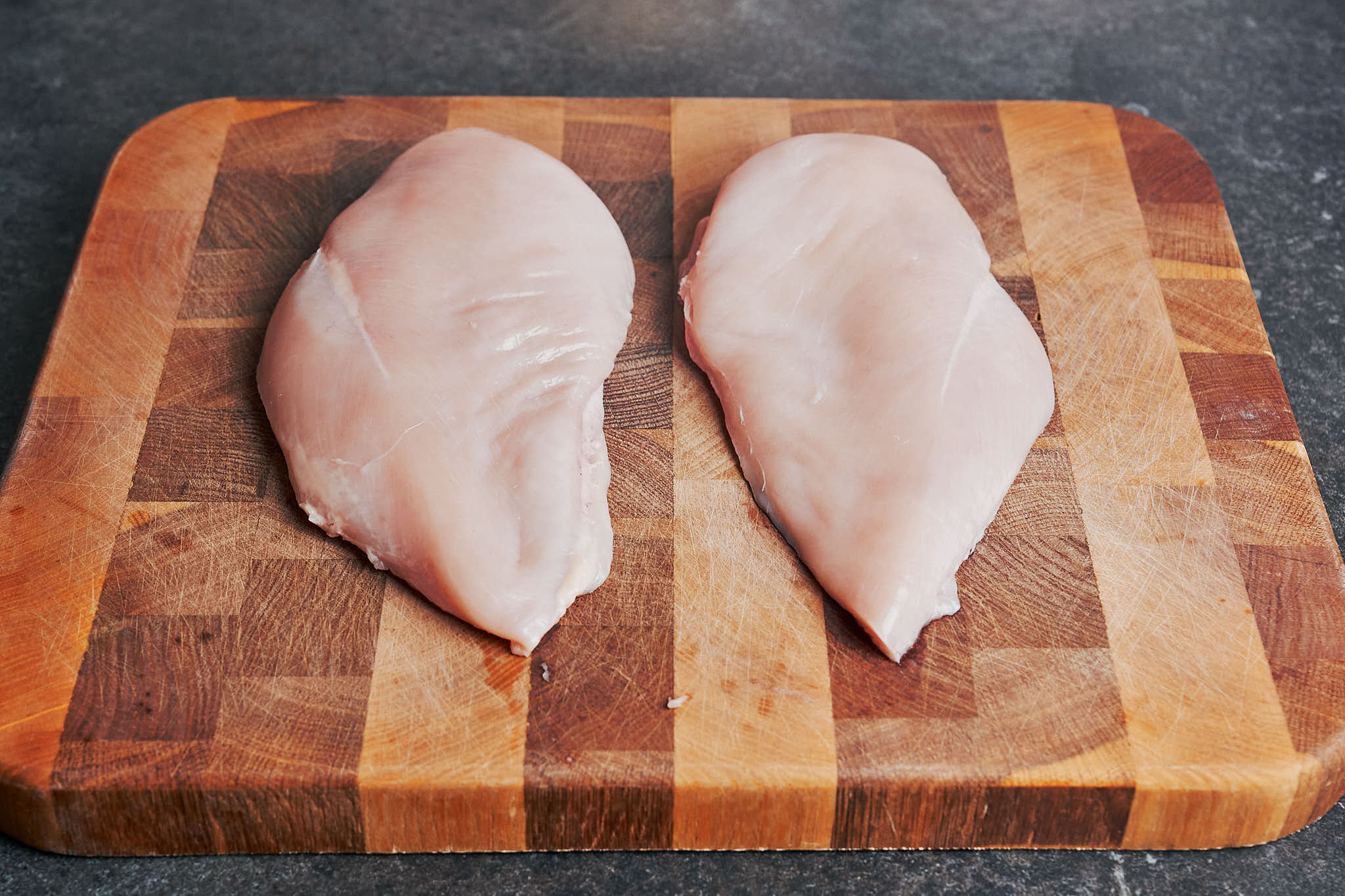 Raw chicken on a wooden cutting board before cooking