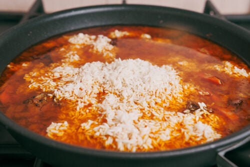 Rice added over beef in skillet without stirring