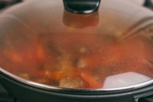 Skillet covered with lid while rice cooks