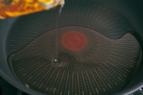 Hot oil poured into skillet for beef and rice