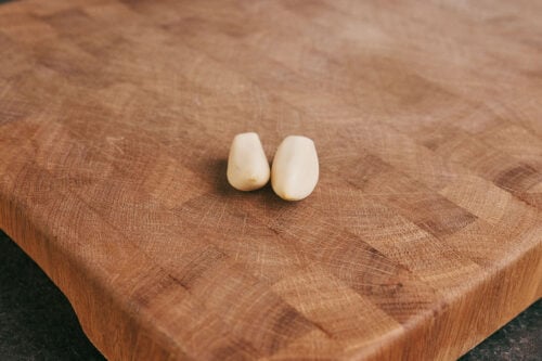 Whole garlic cloves on cutting board