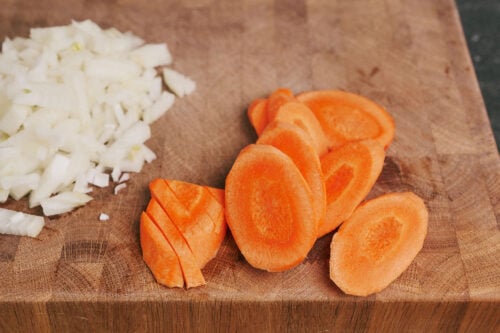 Chopped onion and sliced carrot on cutting board