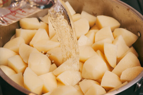 Water poured over potatoes and pork for simmering