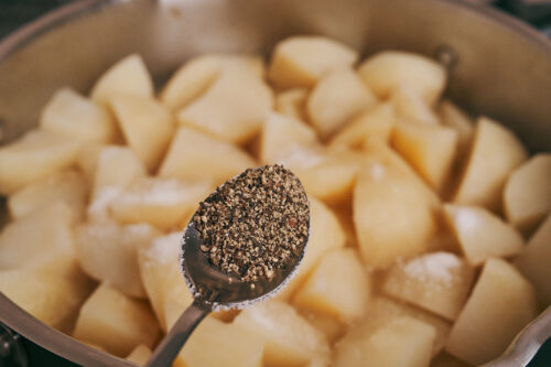 Seasoning potatoes and pork with black pepper