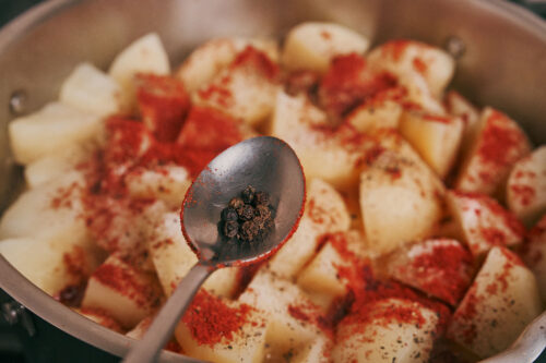 Whole peppercorns added to potatoes and pork during simmering