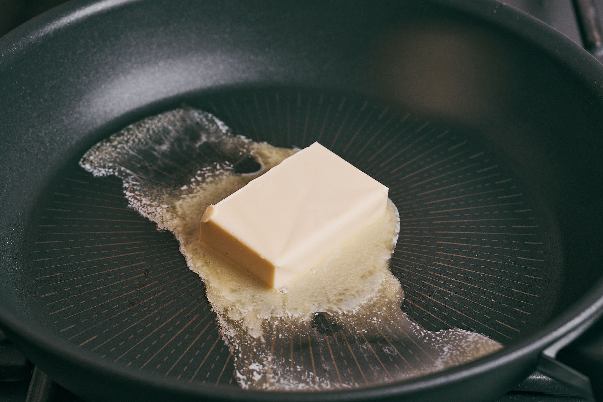 Butter melting in a skillet to start the onion base for beef soup