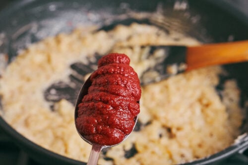 Tomato paste added to the onion base for beef soup