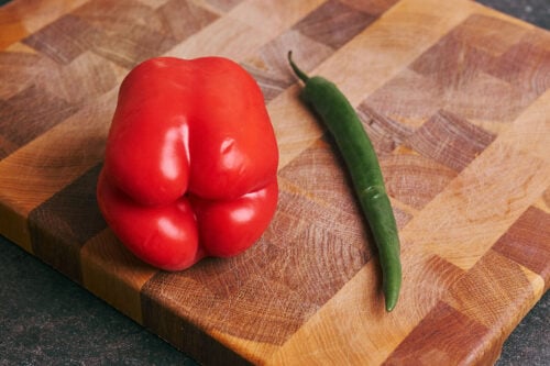 Red bell pepper and chili pepper on a cutting board