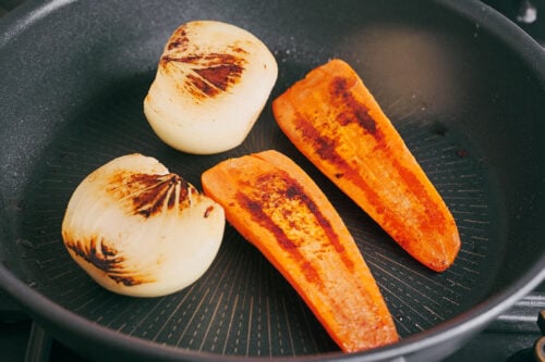 Lightly roasted onion and carrot adding depth to beef soup