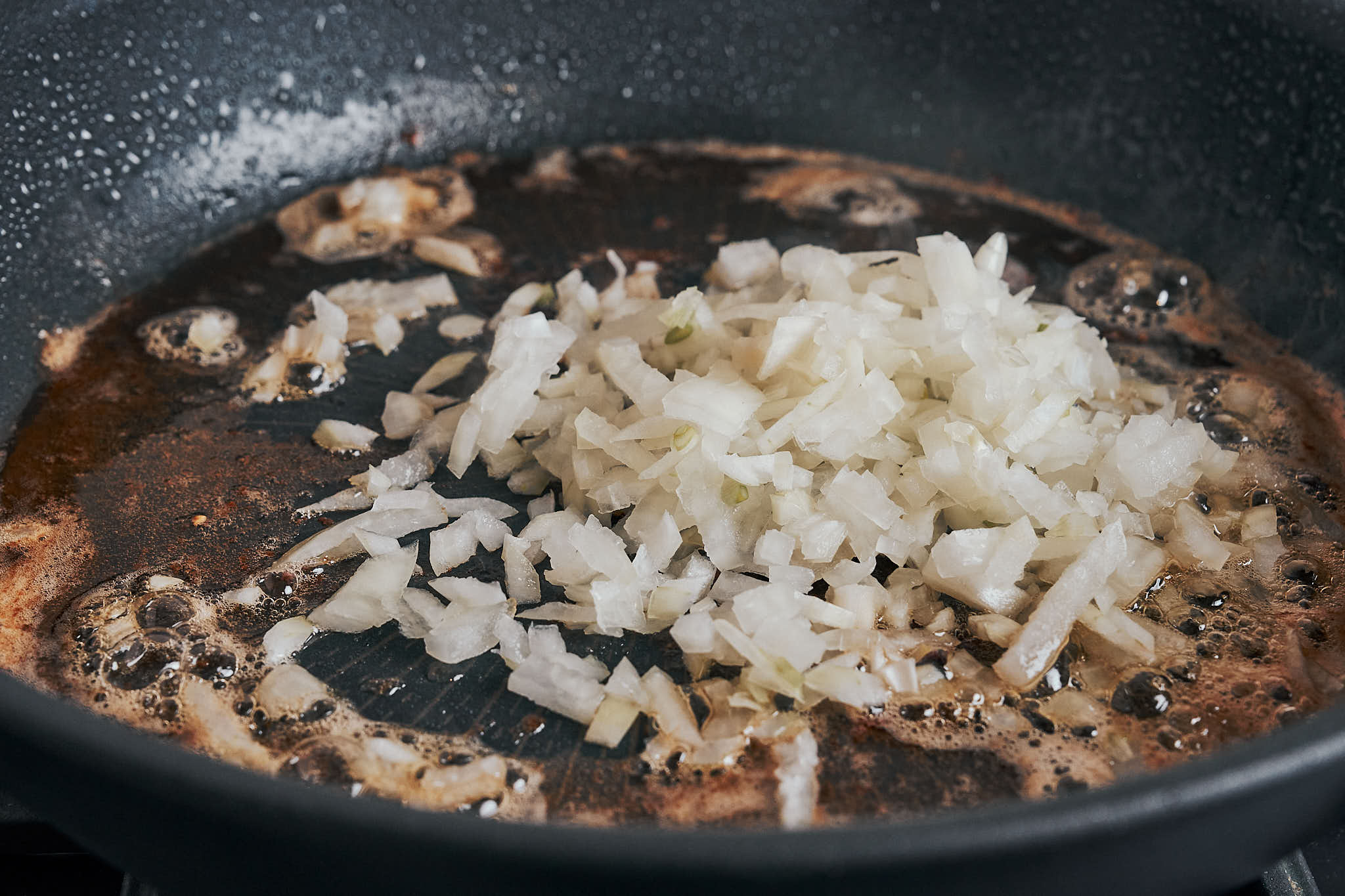 Chopped onion added to a skillet to start the sauce