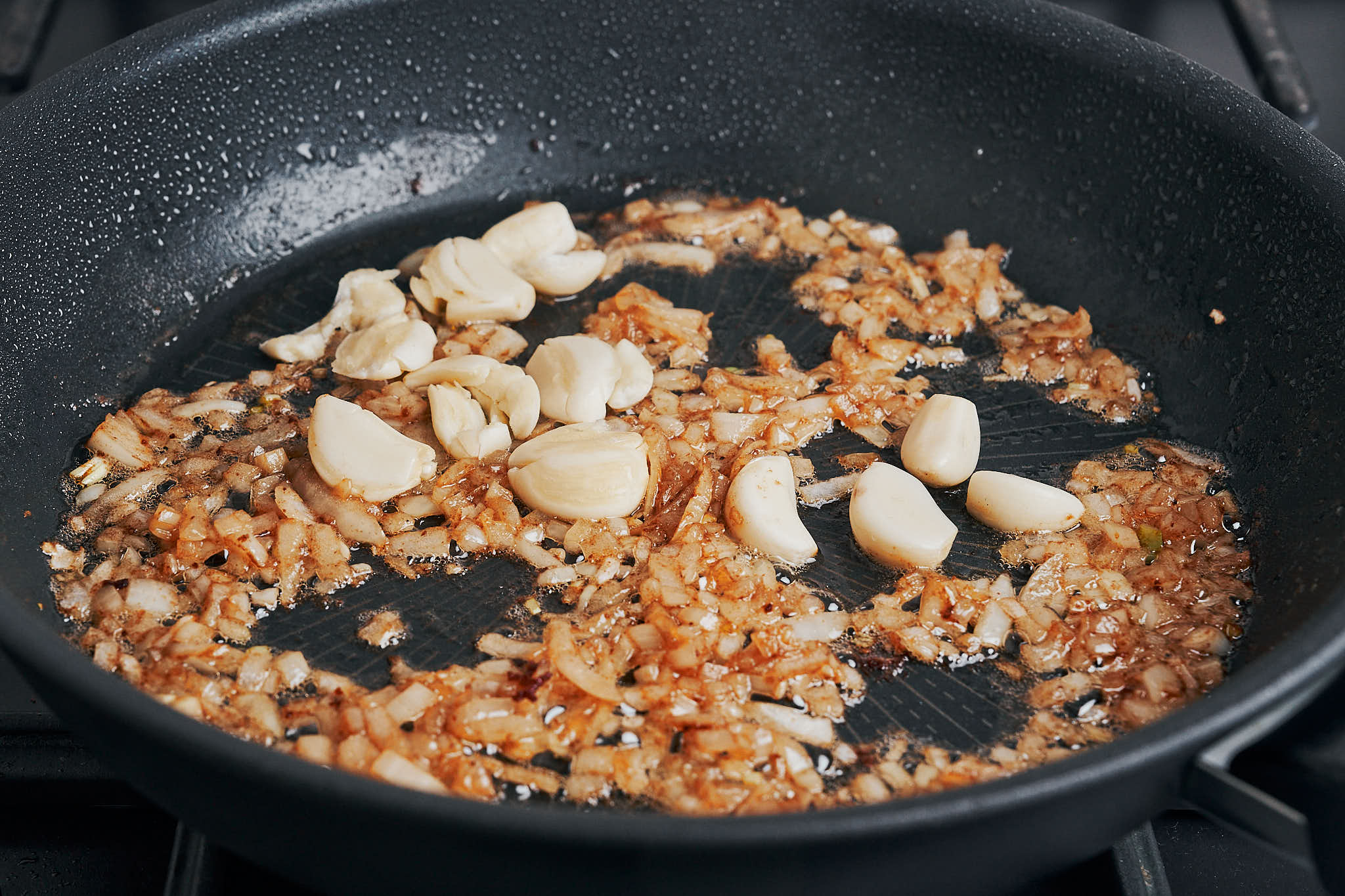 Garlic cloves added to the skillet with softened onions