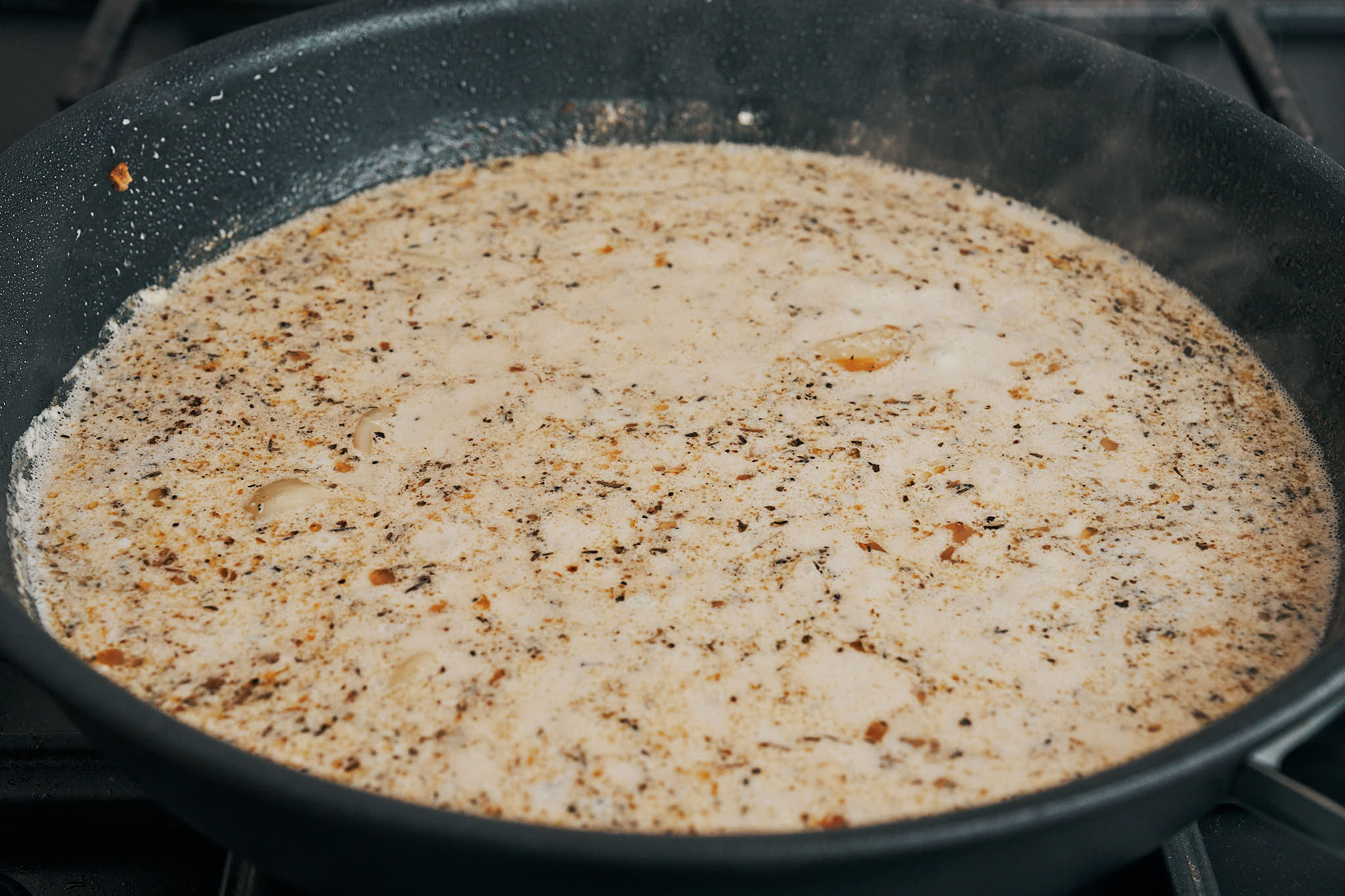 Creamy garlic sauce simmering in a skillet
