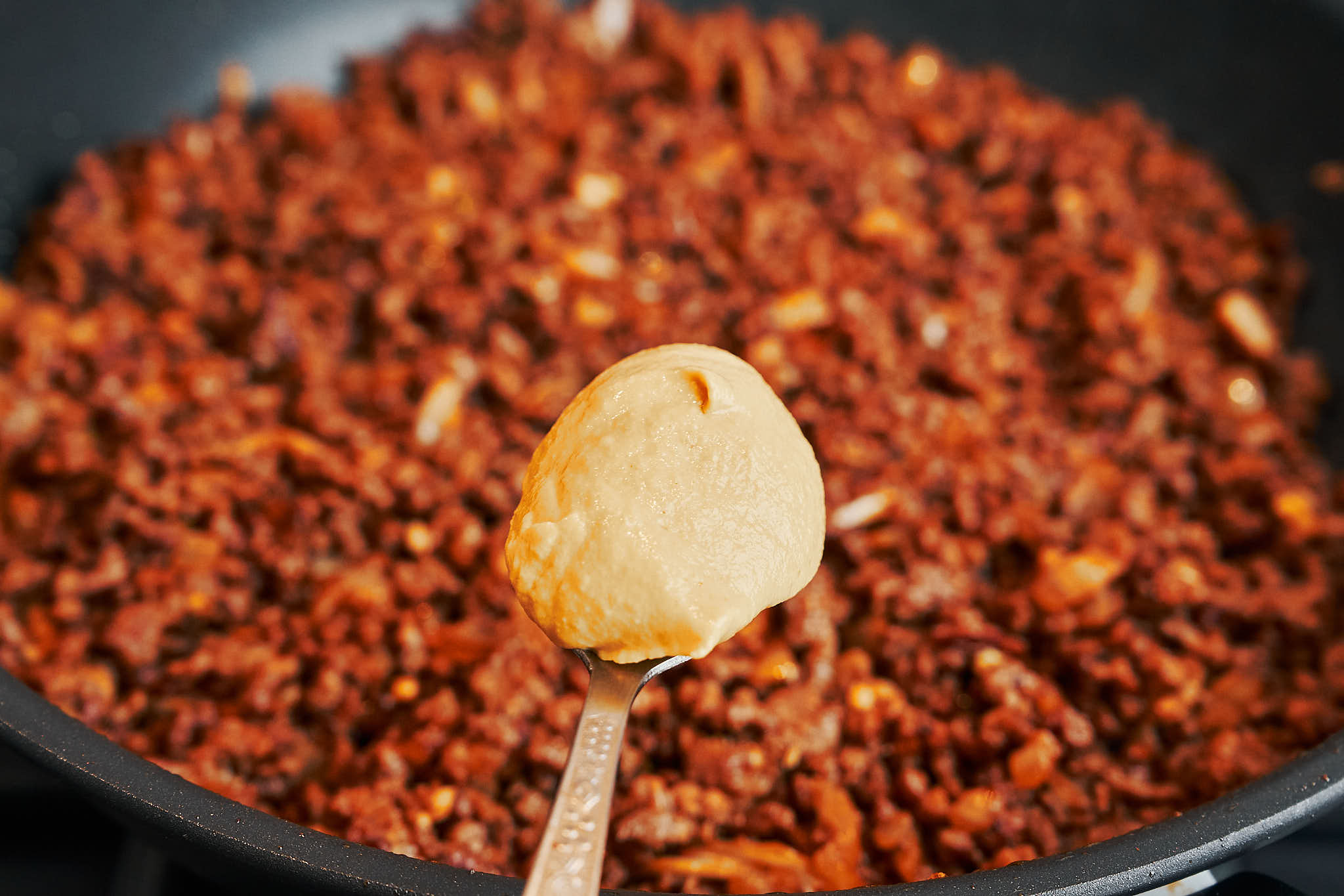 Stirring Dijon mustard into browned ground beef