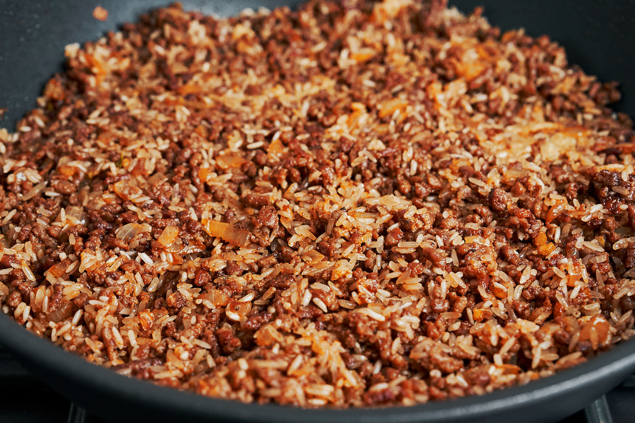 Rice stirred into ground beef until well combined in a skillet