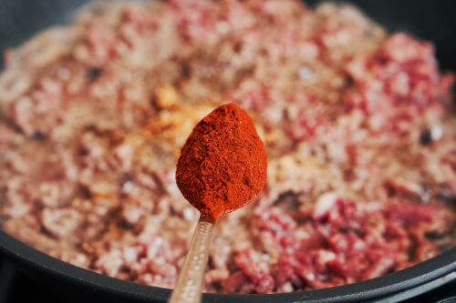 Adding paprika to ground beef in a skillet