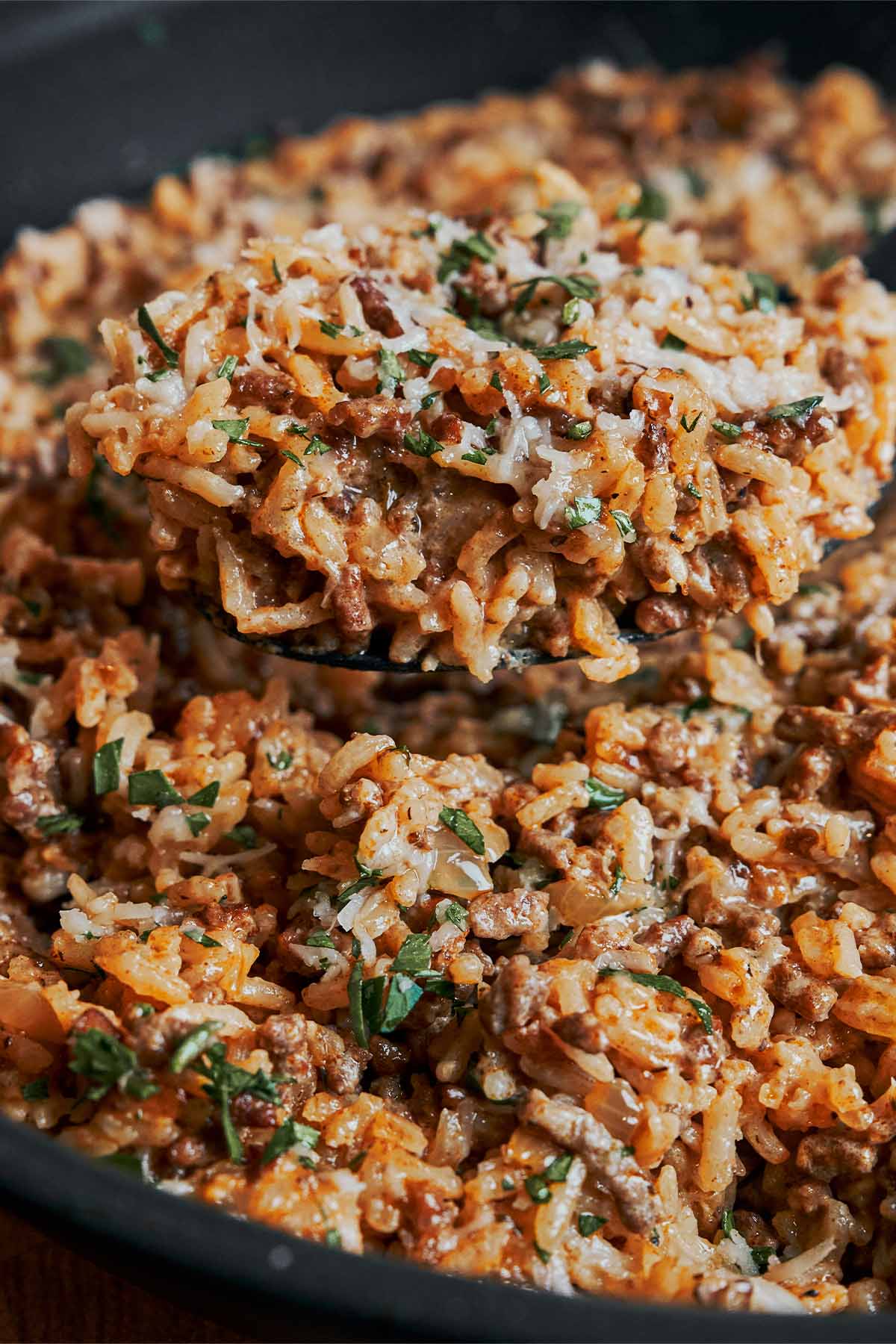 Creamy ground beef and rice skillet topped with Parmesan and fresh parsley