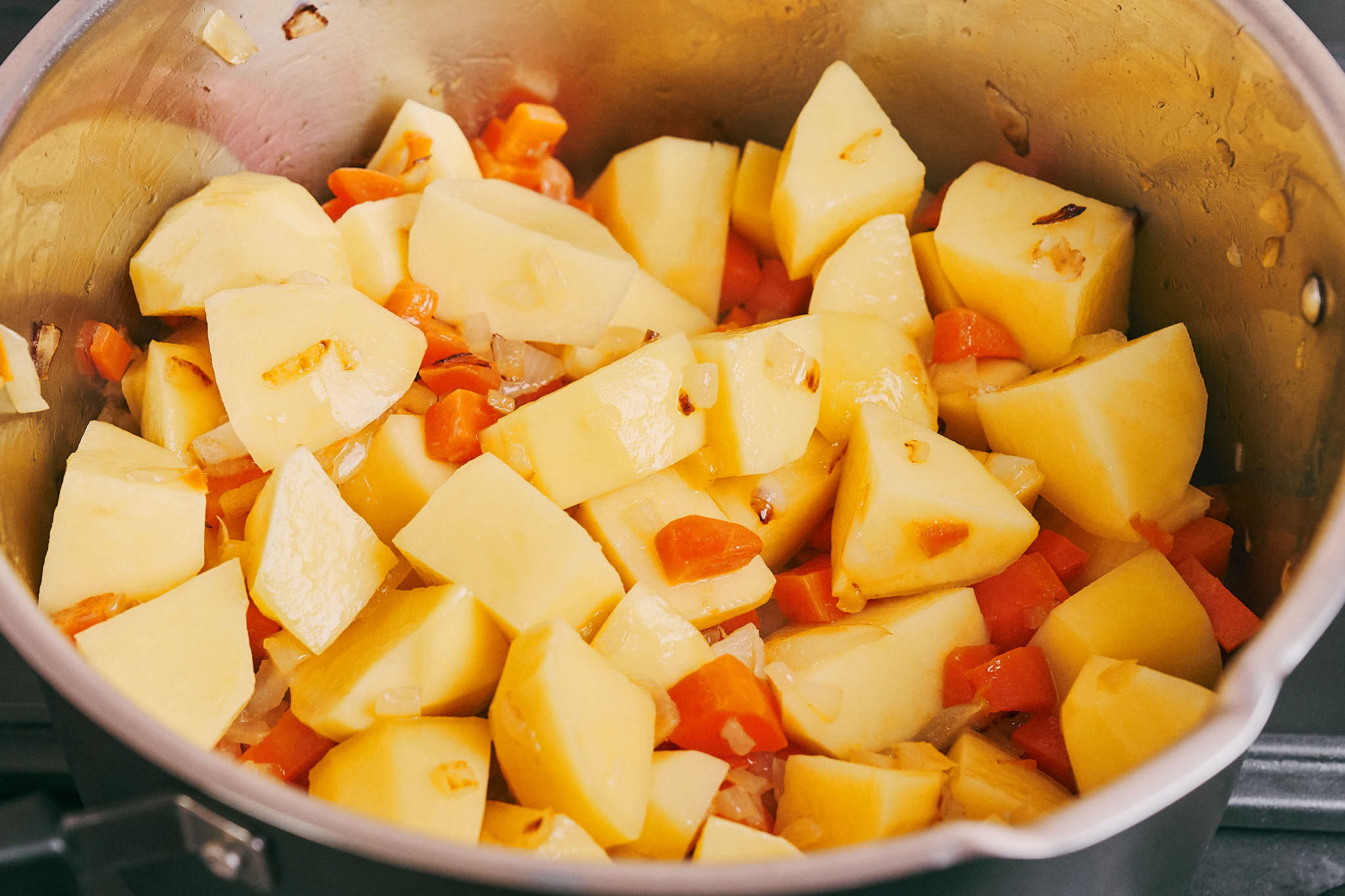 diced potatoes, onion, and carrot in a pot