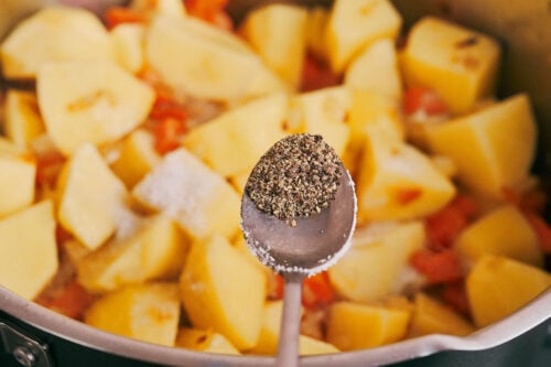 adding black pepper to potato soup ingredients