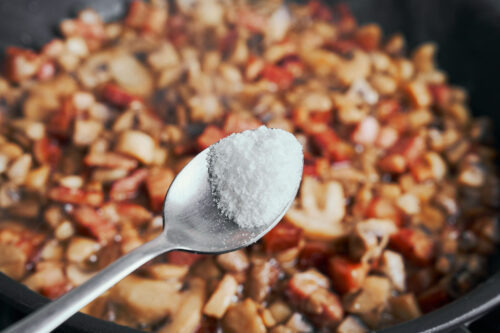 adding salt to mushrooms and bacon