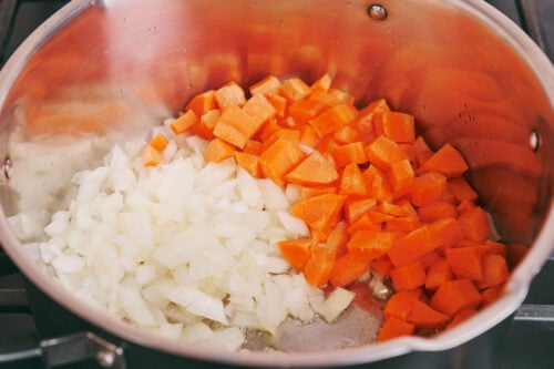 chopped onion and carrot cooking in a pot