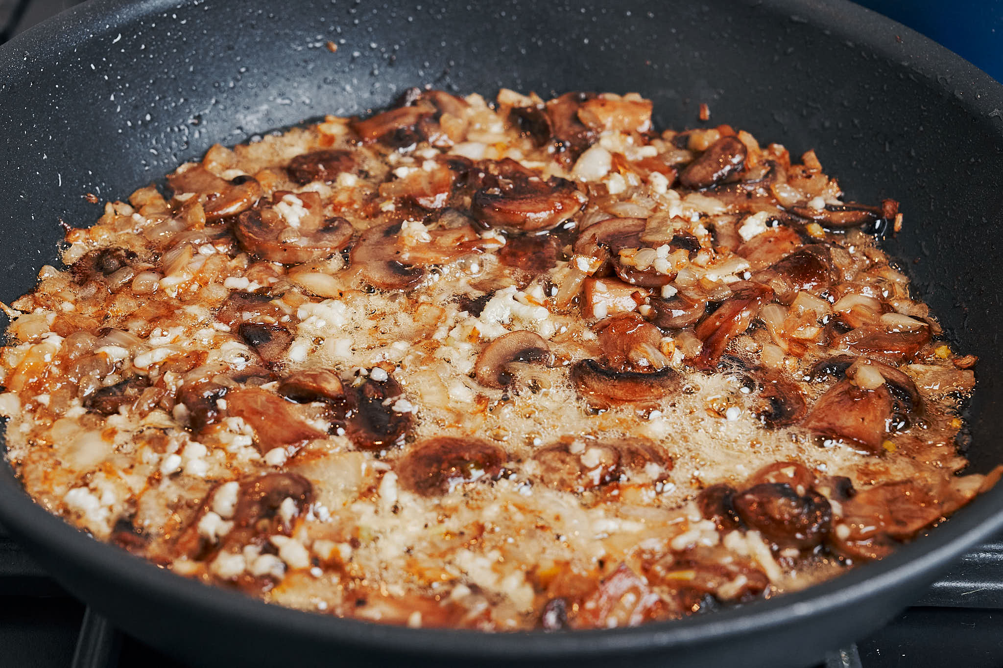 garlic sautéing with mushrooms and onions in a skillet
