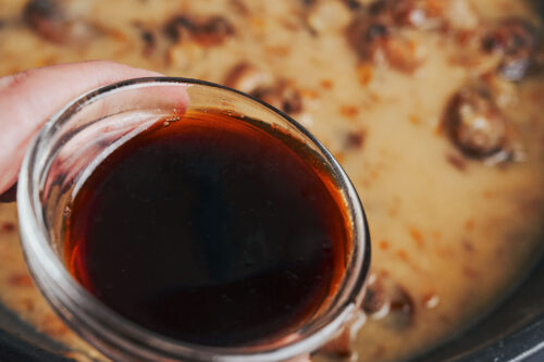 adding soy sauce to the mushroom sauce