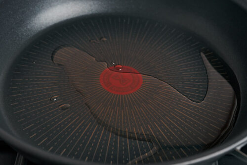 heated skillet with oil for searing pork chops