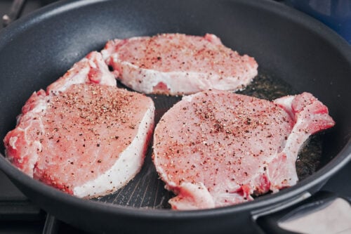 searing pork chops in a hot skillet