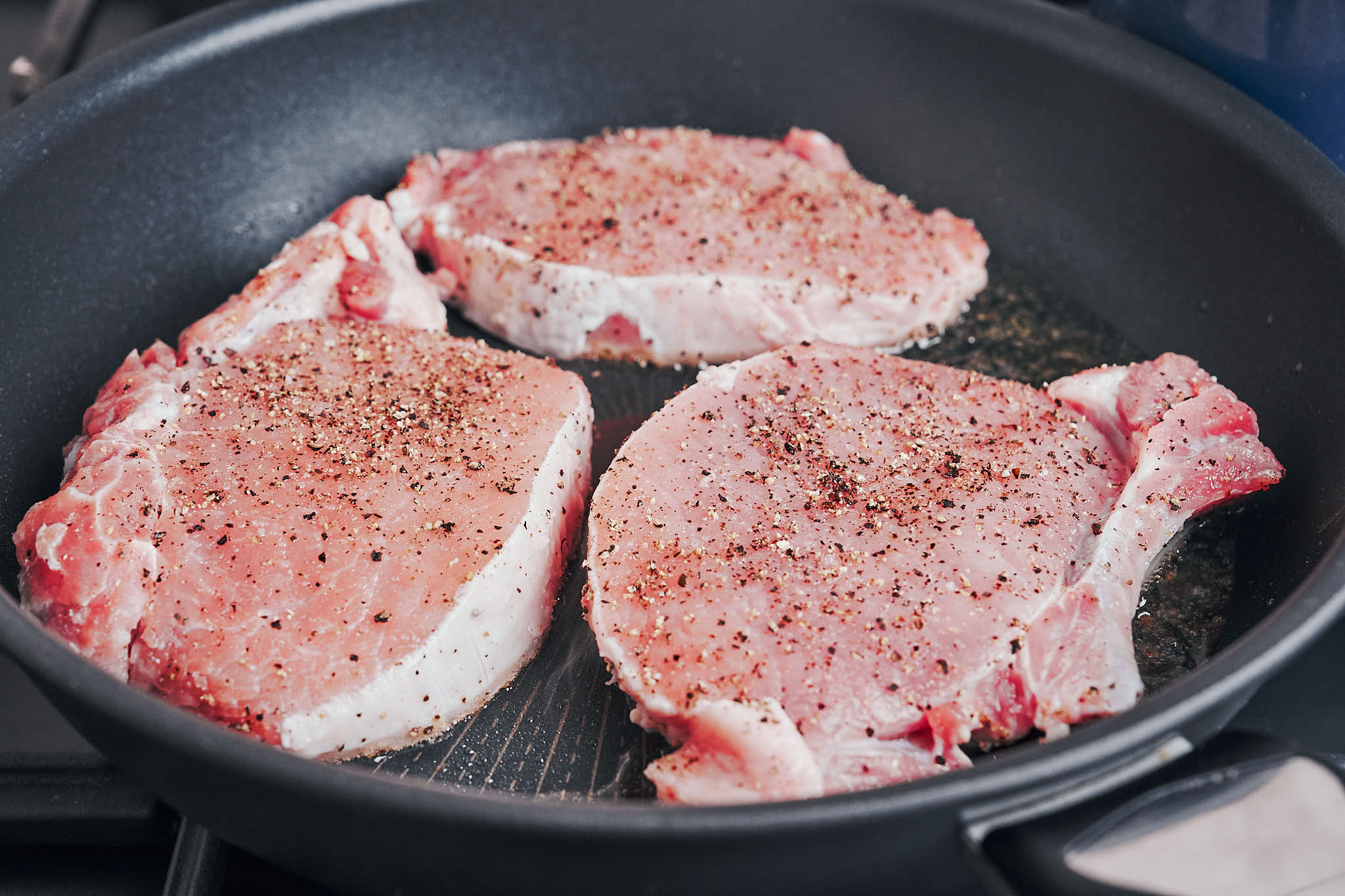 searing pork chops in a hot skillet
