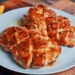 Juicy lemon honey butter chicken served on a plate with glossy sauce